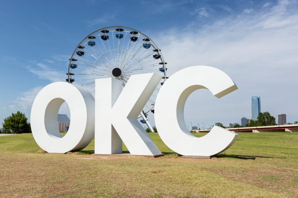 OKC sign in front of the Ferris wheel in the background.
