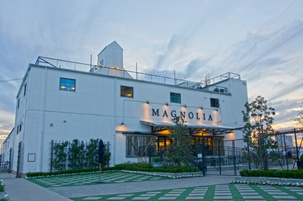 The sun sets behind the Magnolia Market building in Waco, TX.