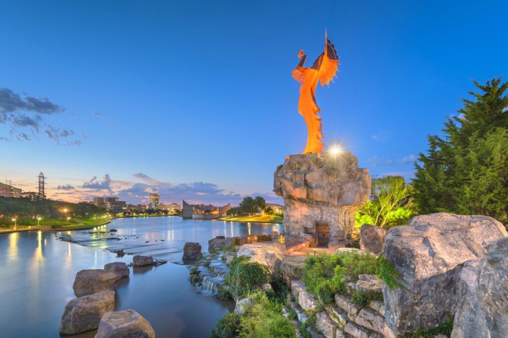 The Keeper of the Plains at dawn, illuminated by an orange light.