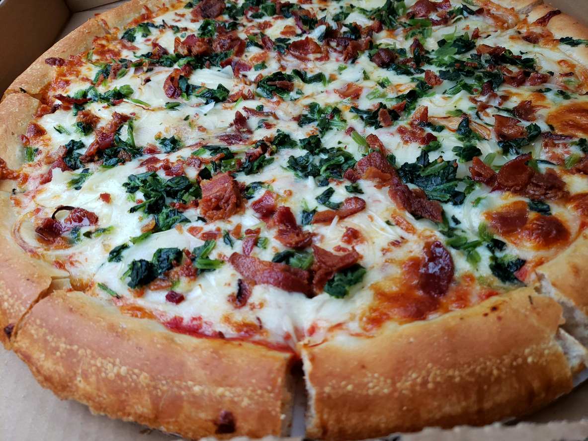 Bacon, spinach, and onion pizza